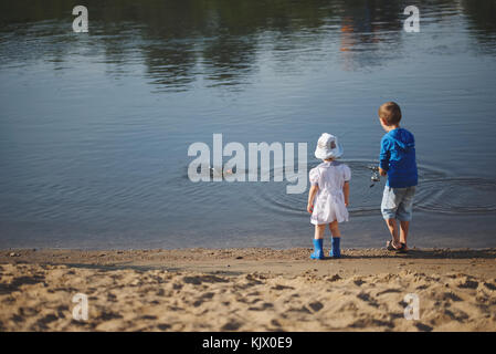 Jungen und Mädchen mit der Stange an der Küste des Flusses Stockfoto