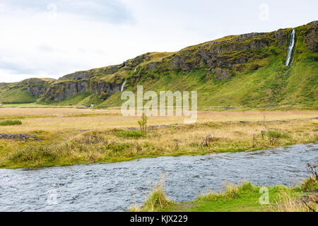 Reisen nach Island - riverside von seljalands River in der Nähe der Wasserfall Seljalandsfoss in Katla Geopark auf isländischen atlantischen Südküste im September Stockfoto