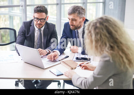 Gruppe von Zusammengeschlossenen Finanzmanager auf geräumige offene Büro zu sitzen und gemeinsam mit dem Jahresabschluss Stockfoto