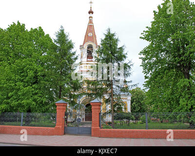 LIEPAJA, LETTLAND - 2. JUNI 2015: Die orthodoxe Kathedrale der Heiligen Dreifaltigkeit befindet sich in der Barinu Straße hinter den großen Bäumen, Blick auf den Vordereingang. Stockfoto