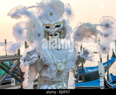 Kostümierte Venezianischen vor der Gondeln in St. Mark's Square während des Karnevals in Venedig, Italien. Stockfoto