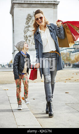 Stilvolle Herbst in Paris. in voller Länge Porträt von glücklich moderne Mutter und Tochter mit Tüten in Paris, Frankreich, Wandern Stockfoto