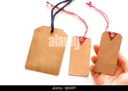 Nahaufnahme der Hand leer braunen Karton preis Tag oder Etikett, Preis auf weißem Hintergrund. Stockfoto