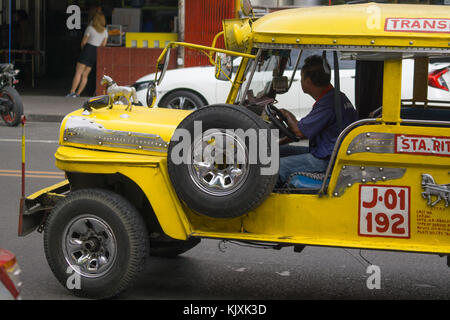 Eine gelbe Public Utility Jeepney Fahrzeug in Olongapo City, Bataan, Philippinen angetrieben Stockfoto