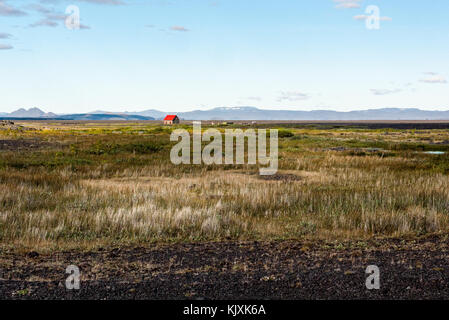 Eine kleine red-roofed Hütte in der Mitte einer Wüste Landschaft in der isländischen Wildnis verloren Stockfoto