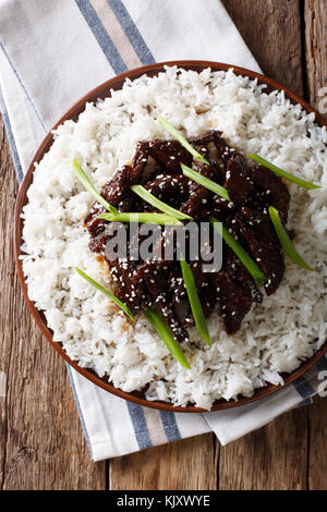 Würzige mongolischen Rind mit Reis close-up auf dem Tisch. Senkrechte Draufsicht von oben Stockfoto