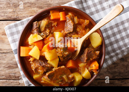 Estofado würziger Eintopf mit Rindfleisch und Gemüse in einer Schüssel close-up auf dem Tisch. horizontal oben Ansicht von oben Stockfoto