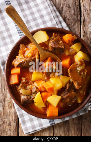 Estofado würziger Eintopf mit Rindfleisch und Gemüse in einer Schüssel close-up auf dem Tisch. Senkrechte Draufsicht von oben Stockfoto