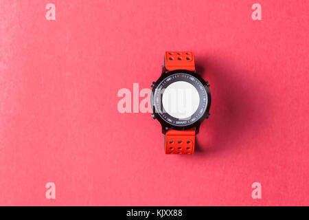 Red Smartwatch auf rotem Hintergrund. Nützlich für Business/tech/Sport/Aktivitäten Präsentation Hintergrund Stockfoto