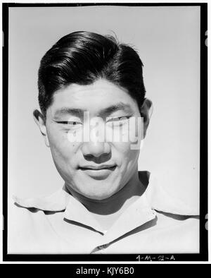 Ansel Adams fotografierte ein Porträt von Henry Hanawa, einem Mechaniker im Manzanar Relocation Center während des Zweiten Weltkriegs. Das Foto, Teil von Adams' dokumentarischem Werk, spiegelt das Leben japanischer Amerikaner in Internierungslagern während des Krieges wider. Stockfoto