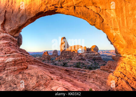 Turret Arch bei Sonnenaufgang im Norden Fenster Natural Arch im Abschnitt Windows des Arches National Park, in der Nähe von Moab, Utah Stockfoto