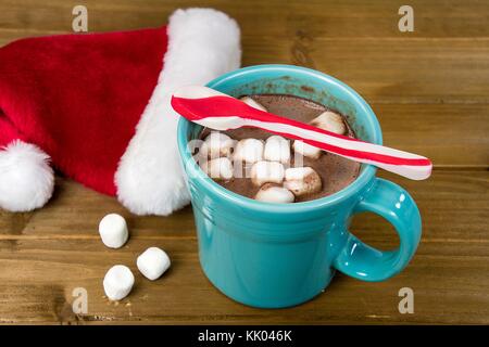 Pfefferminze gestreiften Löffel auf heiße Schokolade trinken mit Marshmallow und Santa Mütze auf rustikalem Holz Stockfoto