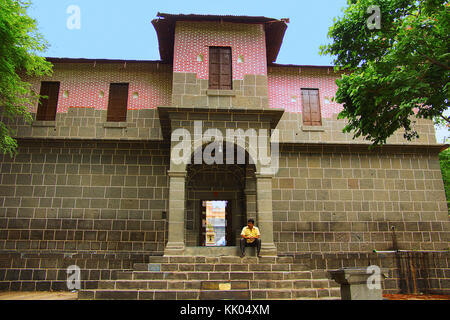 Mann sitzt auf Stufen, außen von Vitthal Mandir, Vithalwadi Wadi, Prati Pandharpur, Pune Stockfoto