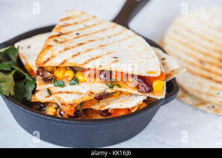Vegetarische quesadilla mit Gemüse und Käse in Gusseisen Bratpfanne, hellen Hintergrund. Vegetarische gesunde Ernährung Konzept. Stockfoto