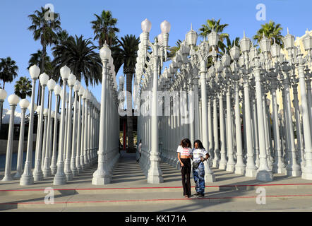 Jugendmädchen Touristen stehend von Urban Light art Installation am Eingang LACMA Los Angeles County Museum of Art, LA CALIFORNIA KATHY DEWITT Stockfoto