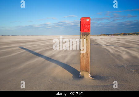 Red Beach Pole auf einem großen, stürmischen Strand Stockfoto