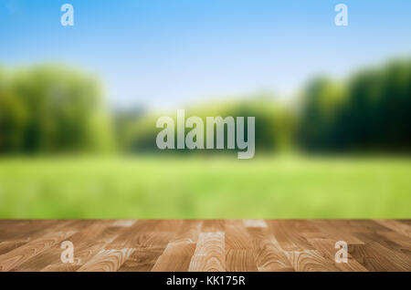 Leerer Holztisch mit Garten-Bokeh Stockfoto