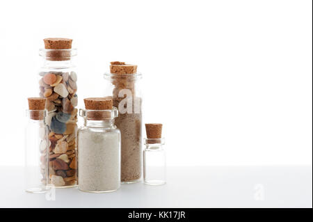 Glasflaschen mit Sand auf dem weißen Hintergrund Stockfoto