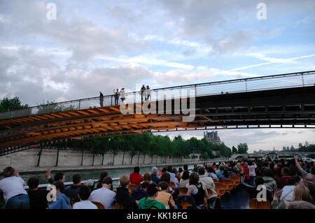 Touristen auf eine Sightseeing Bootsfahrt auf der Seine in Paris winkenden Menschen stehen oben auf der Brücke Stockfoto