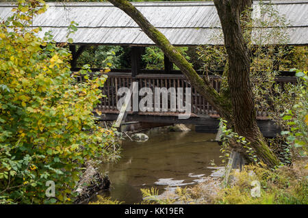 Alte hölzerne Brücke über einen idyllischen Nebenfluß im südlichen Österreich Stockfoto