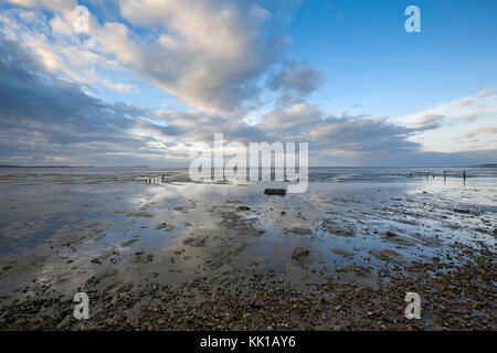 Interessante Wolken in Pools von Wasser bei Ebbe wider, Seasalter Strand, Whitstable, Kent, Großbritannien, mit Blick über die Swale Mündung. Stockfoto