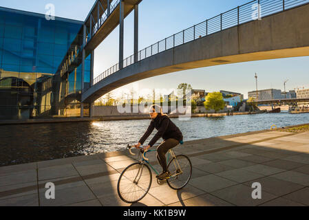 Eine junge Frau radelt unter der Spree-Brücke, die das Maria-Elisabeth-Luders-Haus mit dem Paul Lobe-Haus verbindet. Stockfoto