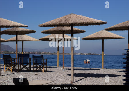 Leeren Strand Sonnenschirme in einer Reihe mit Stühlen auf einem Herbst sonnig schönen Tag Stockfoto