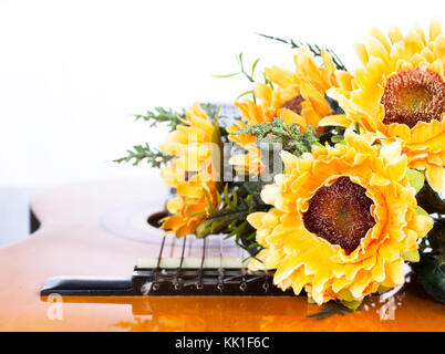 Künstliche Sonnenblumen auf der klassischen Gitarre Stockfoto