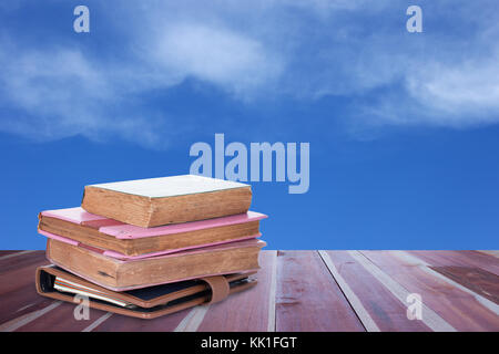 Alte Bücher über Holzbohlen mit blauem Himmel Stockfoto