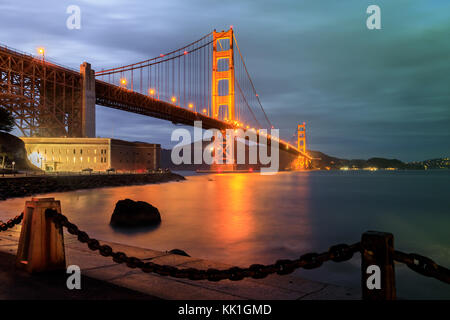 Golden Gate Bridge und Maschendrahtzaun in der Nacht. Stockfoto