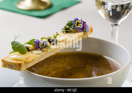 Stilvolle gourmet Zwiebelsuppe dekoriert mit Toast Scheibe Stockfoto