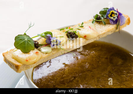 Stilvolle gourmet Zwiebelsuppe dekoriert mit Toast Scheibe Stockfoto