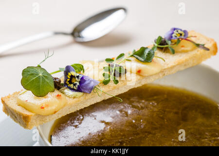 Stilvolle gourmet Zwiebelsuppe dekoriert mit Toast Scheibe Stockfoto