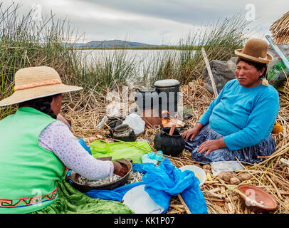 Native uro Familie Vorbereitung einer Mahlzeit, schwimmenden Inseln der Uros, Titicacasee, Puno, Peru Stockfoto