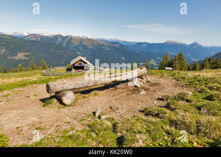 Holz- Hirte Lodge auf einem Hochland Weide mit Wassertrog und alpine Bergwelt im Westen von Kärnten, Österreich. Stockfoto