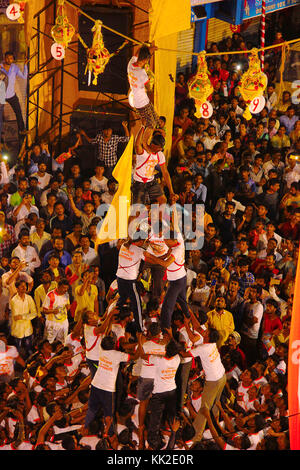 Govindas, Junge, umgeben von Menschenmengen, machen eine menschliche Pyramide, um Dahi Handi zu brechen, Pune Stockfoto