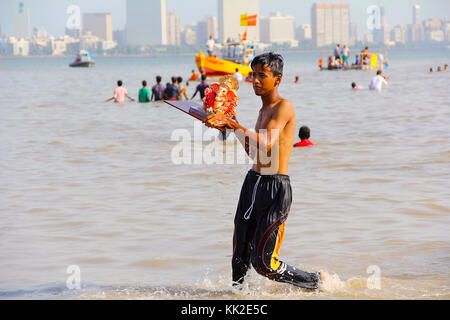 Junge, der Ganapati-Idol zum Eintauchen nimmt, Ganapati Visarjan, Girgaon Chowpatty, Mumbai Stockfoto