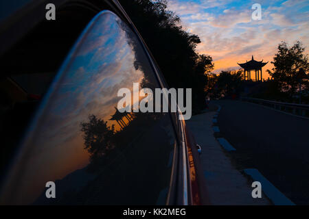 Ningbo, Ningbo, China. November 2017. Ningbo, CHINA-26. November 2017:(NUR FÜR REDAKTIONELLE VERWENDUNG. CHINA OUT) . Das Spiegelbild eines Pavillons kann man am Fenster eines Autos in der Abenddämmerung im Golden Goose Lake Scenic Area in Ningbo, der ostchinesischen Provinz Zhejiang, sehen. Quelle: SIPA Asia/ZUMA Wire/Alamy Live News Stockfoto