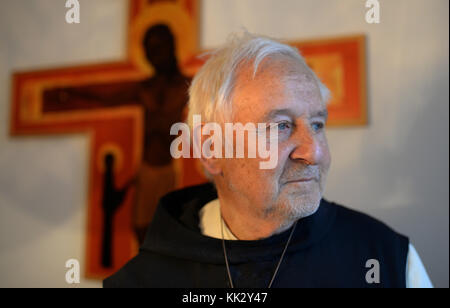 Pater Stephan Senge sitzt vor einem an einer Wand hängenden Kreuz in der Kapelle des Klosters Himmerod bei Großlittgen in der Südeifel, 21. November 2017. Der 83-Jährige ist der letzte Zisterziensermönch in der Abtei Himmerod. Die Abtei, in der einst etwa 20 Mönche lebten, wurde kürzlich aufgrund von Personalmangel und Finanzknappheit aufgelöst. Foto: Harald Tittel/dpa Stockfoto