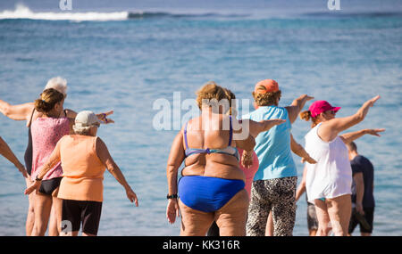 Ältere Frauen aus der Region durchlaufen ihre Routine bei ihrer täglichen Keep-Fit-Klasse am Strand in Spanien. Stockfoto