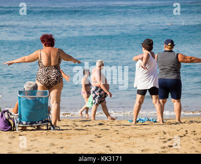 Ältere Frauen aus der Region durchlaufen ihre Routine bei ihrer täglichen Keep-Fit-Klasse am Strand in Spanien. Stockfoto