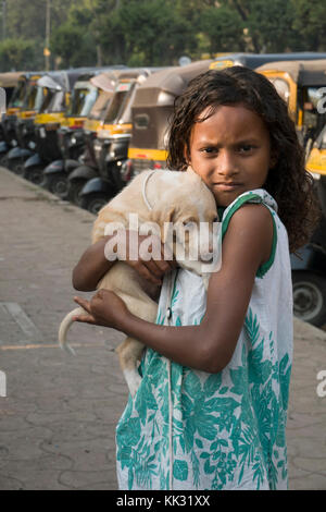 Junge indische Mädchen hält Pet puppy dog Stockfoto