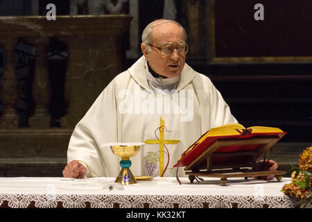 Pavia, Italien. November 11 2017. Ein Priester, der eine heilige Messe im Duomo di Pavia (Kathedrale von Pavia) feiert. Er betet über Brot und Wein auf dem alt Stockfoto