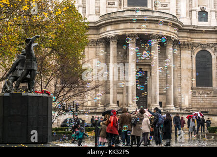 Mann, der an die St Paul's Kathedrale, unterhaltsame Kinder und Leute, die große Blasen, London, England, Großbritannien Stockfoto