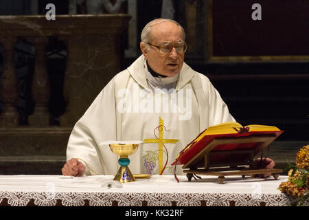 Pavia, Italien. November 11 2017. Ein Priester, der eine heilige Messe im Duomo di Pavia (Kathedrale von Pavia) feiert. Er betet über Brot und Wein auf dem alt Stockfoto