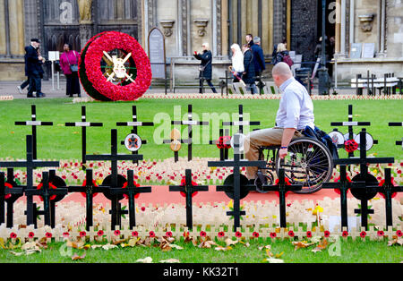 London, England, UK. Kreuze und Mohn auf dem Gelände von Westminster Abbey, den 11. November 2017 - Mann in einem wheelchiar suchen Stockfoto