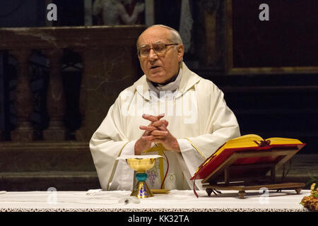 Pavia, Italien. November 11 2017. Ein Priester, der eine heilige Messe im Duomo di Pavia (Kathedrale von Pavia) feiert. Er betet über Brot und Wein auf dem alt Stockfoto