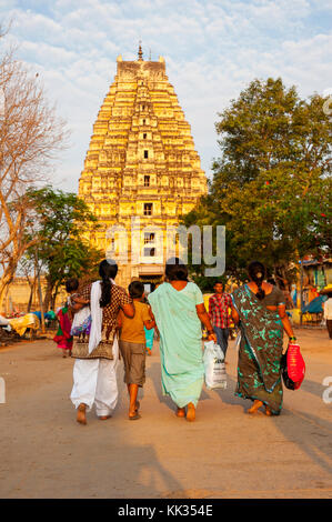 Indische Frau in traditioneller Kleidung Wandern am Basar Straße mit Sri Virupaksha Temple im Hintergrund, Hampi, Karnataka, Indien Stockfoto