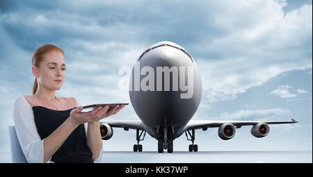 Digital composite von Frau mit Tablet vor dem Flugzeug Stockfoto