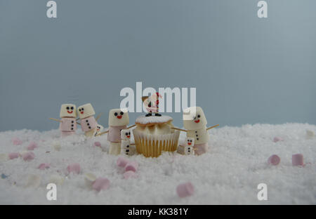 Weihnachten essen Fotografie Bild mit Sahne schwamm Fee Kuchen im Schnee mit Marshmallows, der so glücklich Schneemann und Santa Hut geformte platziert Stockfoto